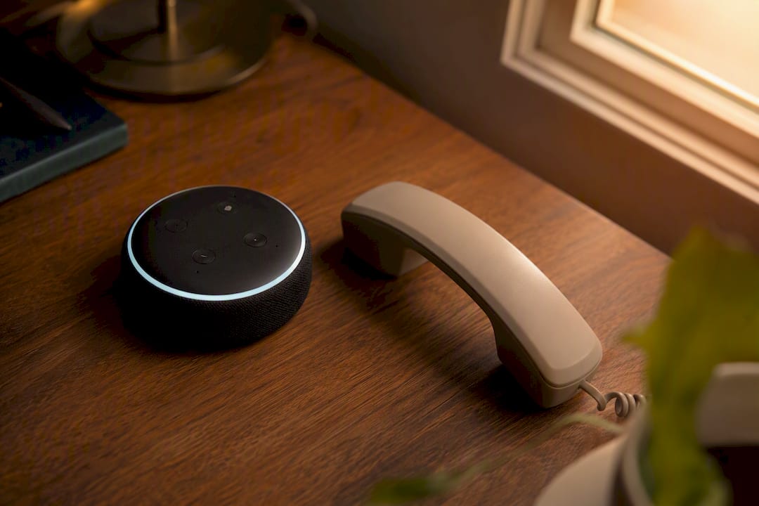 Voice assistant and phone on desk ready for calls