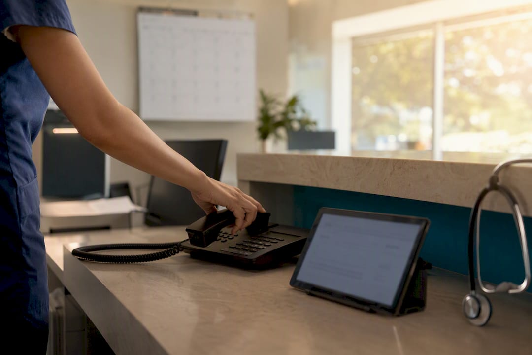 Hand placing phone handset down in medical office